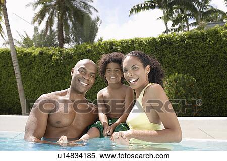 Stock Photography - Parents with son (5-6 tears) in pool portrait. Fotosearch