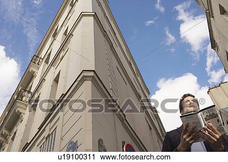 Paris France Man with guide book in front of apartment blocks View Large Photo Image Stock Image - Paris France Man with guide book in front of apartment blocks. Fotosearch