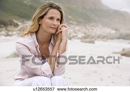 Pensive woman sitting on beach View Large Photo Image Stock Photo - Pensive woman sitting on beach. Fotosearch