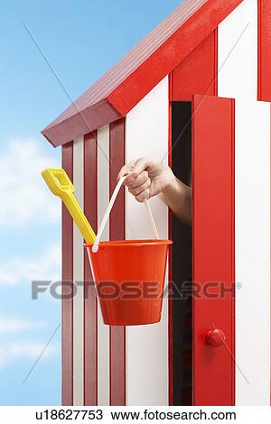 Person holding bucket and spade standing in beach cabin View Large Photo Image Stock Image - Person holding bucket and spade standing in beach cabin. Fotosearch