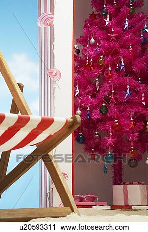 Stock Image - Pink christmas tree in beach storage cabin. Fotosearch