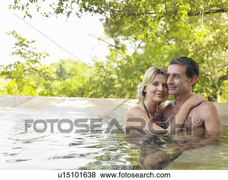 Portrait of adult couple embracing in pool smiling View Large Photo Image Stock Photo - Portrait of adult couple embracing in pool smiling. Fotosearch