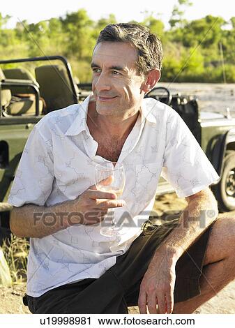 Portrait of adult man holding wineglass outdoors View Large Photo Image Stock Image - Portrait of adult man holding wineglass outdoors. Fotosearch
