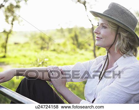 Stock Photo - Portrait of adult woman sitting wearing hat thinking. Fotosearch