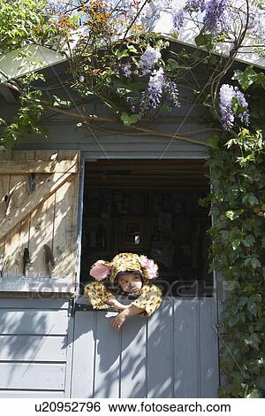Stock Photograph - Portrait of boy (5-6) in jaguar costume in shed. Fotosearch