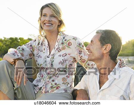 Picture - Portrait of couple outdoors man looking at woman smiling. Fotosearch