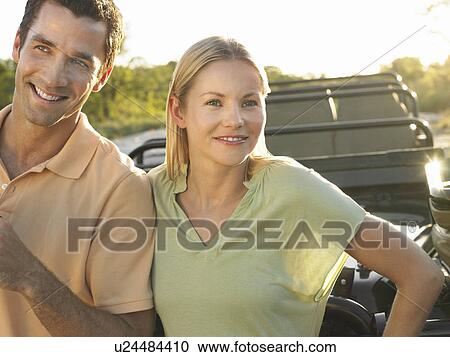 Portrait of couple outdoors standing by jeep smiling View Large Photo Image Stock Image - Portrait of couple outdoors standing by jeep smiling. Fotosearch