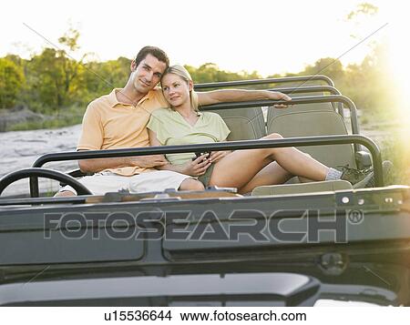 Picture - Portrait of couple sitting in jeep. Fotosearch