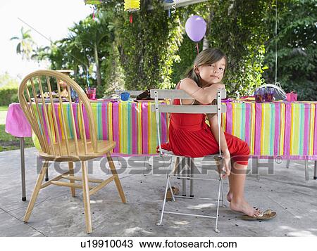 Portrait of girl (7-9) sitting at table after birthday party View Large Photo Image Stock Image - Portrait of girl (7-9) sitting at table after birthday party. Fotosearch