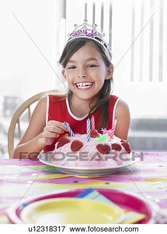 Portrait of girl (7-9) with birthday cake laughing View Large Photo Image Stock Photo - Portrait of girl (7-9) with birthday cake laughing. Fotosearch