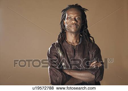 Stock Photo - Portrait of mid adult man with arms crossed. Fotosearch