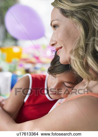 Portrait of mother embracing sleeping daughter (7-9) side view View Large Photo Image Picture - Portrait of mother embracing sleeping daughter (7-9) side view. Fotosearch