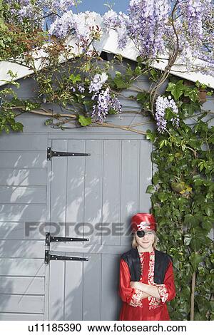 Portrait of young boy (7-9) in pirate costume by shed View Large Photo Image Stock Image - Portrait of young boy (7-9) in pirate costume by shed. Fotosearch