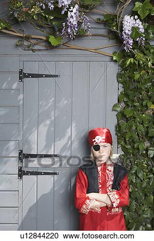 Portrait of young boy (7-9) in pirate costume by shed View Large Photo Image Stock Image - Portrait of young boy (7-9) in pirate costume by shed. Fotosearch
