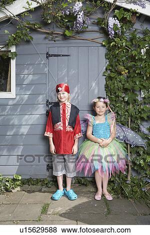 Portrait of young boy (7-9) in pirate costume girl (5-6) in fairy costume by shed View Large Photo Image Stock Photo - Portrait of young boy (7-9) in pirate costume girl (5-6) in fairy costume by shed. Fotosearch