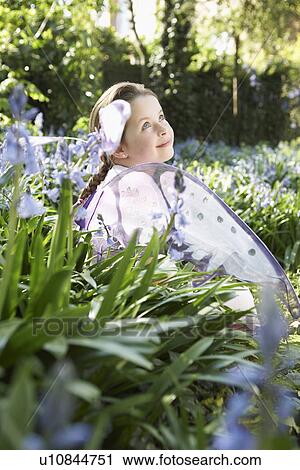 Portrait of young girl (5-6) sitting in flower garden wearing fairy costume smiling View Large Photo Image Stock Image - Portrait of young girl (5-6) sitting in flower garden wearing fairy costume smiling. Fotosearch