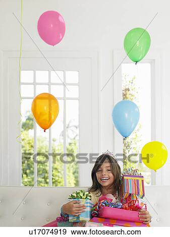 Portrait of young girl (7-9) with birthday presents smiling View Large Photo Image Stock Photo - Portrait of young girl (7-9) with birthday presents smiling. Fotosearch