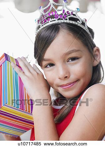 Stock Photography - Portrait of young girl (7-9) with birthday present close-up. Fotosearch