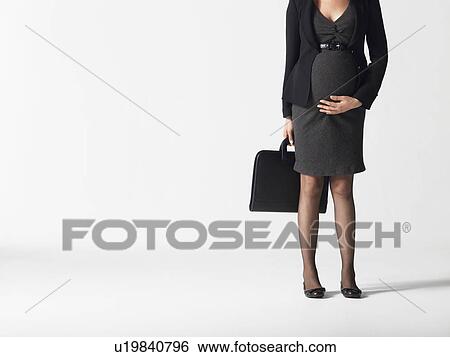 Stock Photograph - Pregnant businesswoman low section. Fotosearch