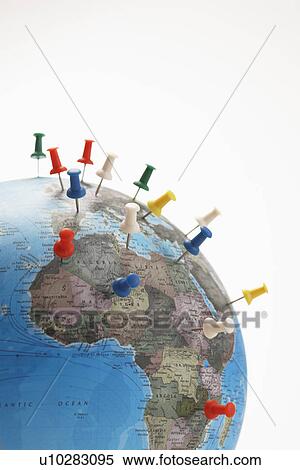 Stock Photography - Push pins in various parts of globe studio shot. Fotosearch