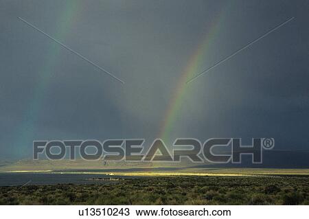 Stock Image - Rainbow over lake. Fotosearch