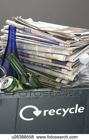 Stock Photo - Recycling bin filled with waste paper and bottles close-up. Fotosearch