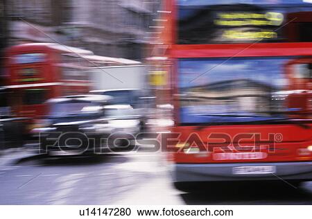 Stock Image - Red buses and black cabs on road in London motion blur. Fotosearch
