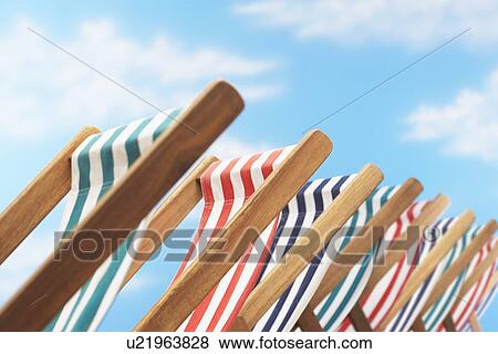 Stock Photo - Row of deck chairs on beach close up. Fotosearch