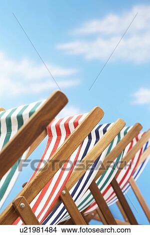 Picture - Row of deck chairs on beach. Fotosearch