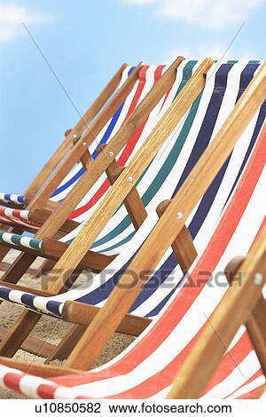 Stock Image - Row of deck chairs on beach. Fotosearch