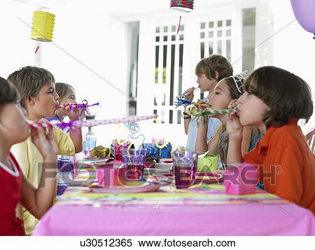 Six children (7-12) at table blowing party puffers side view View Large Photo Image Stock Photography - Six children (7-12) at table blowing party puffers side view. Fotosearch