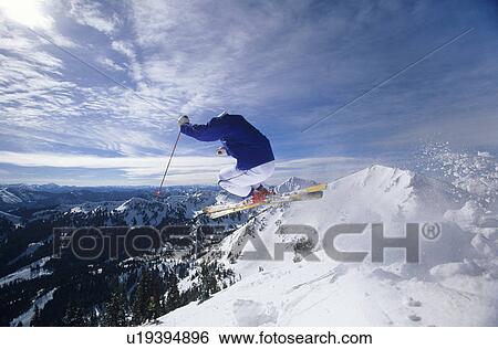 Stock Photograph - Skier jumping on mountain top Hitting the Slopes. Fotosearch