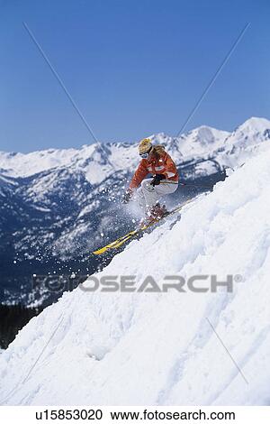 Skier skiing down ski slope side view View Large Photo Image Stock Image - Skier skiing down ski slope side view. Fotosearch