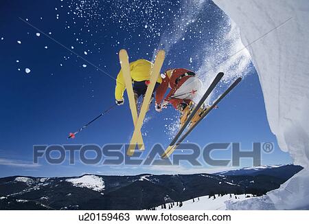 Skiers launching off snow bank Hitting the Slopes low angle view View Large Photo Image Stock Image - Skiers launching off snow bank Hitting the Slopes low angle view. Fotosearch