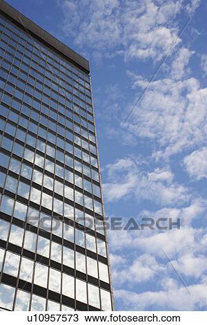 Stock Image - Sky and clouds reflecting in skyscraper windows low angle view. Fotosearch