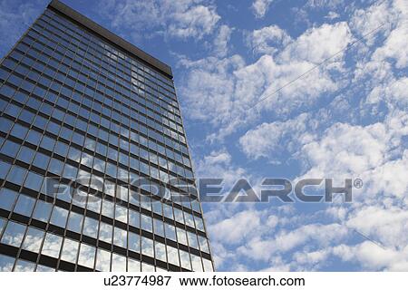 Stock Photo - Sky and clouds reflecting in skyscraper windows low angle view. Fotosearch