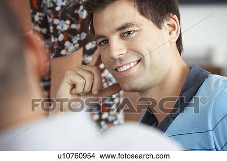 Picture - Smiling Businessman listening to colleague in Meeting. Fotosearch