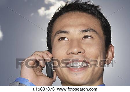 Stock Image - Smiling Businessman Using Cell Phone close-up. Fotosearch