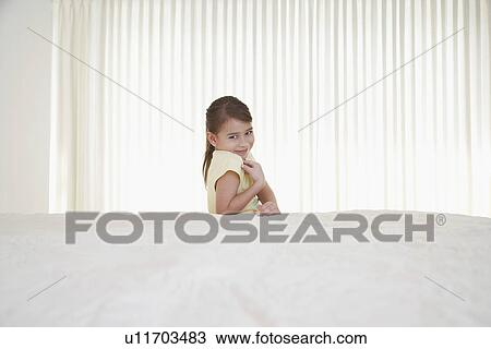 Smiling girl (5-6) behind bed View Large Photo Image Stock Image - Smiling girl (5-6) behind bed. Fotosearch