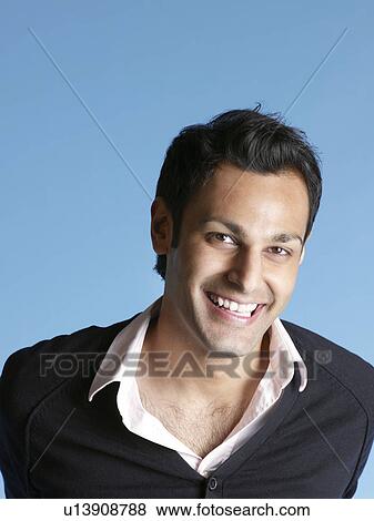 Stock Photo - Smiling mid-adult man on blue background. Fotosearch