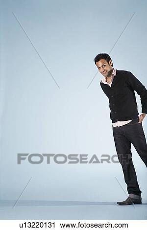 Stock Image - Smiling mid-adult man on blue background (cropped). Fotosearch