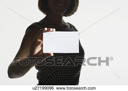 Smiling silhouetted woman standing holding large blank card mid section View Large Photo Image Stock Photograph - Smiling silhouetted woman standing holding large blank card mid section. Fotosearch