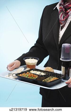 Stewardess holding tray with airplane food mid section View Large Photo Image Stock Photo - Stewardess holding tray with airplane food mid section. Fotosearch