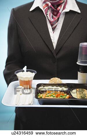 Stock Photo - Stewardess holding tray with airplane food mid section. Fotosearch