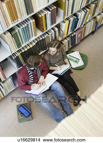 Students sitting on floor doing homework in library View Large Photo Image Picture - Students sitting on floor doing homework in library. Fotosearch