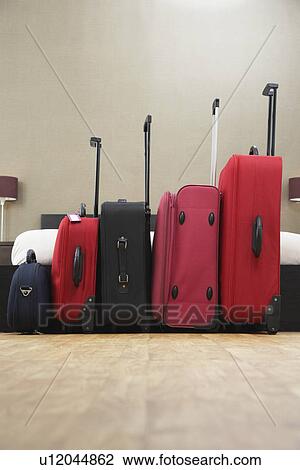 Suitcases standing in row in bedroom View Large Photo Image Stock Image - Suitcases standing in row in bedroom. Fotosearch