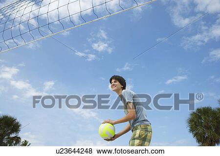 Teenage boy (16-17) playing beach volleyball low angle view View Large Photo Image Stock Photo - Teenage boy (16-17) playing beach volleyball low angle view. Fotosearch