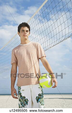 Teenage boy (16-17) standing on beach volleyball court portrait View Large Photo Image Stock Photography - Teenage boy (16-17) standing on beach volleyball court portrait. Fotosearch