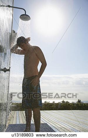 Teenage boy (16-17) standing under outdoor shower View Large Photo Image Stock Image - Teenage boy (16-17) standing under outdoor shower. Fotosearch