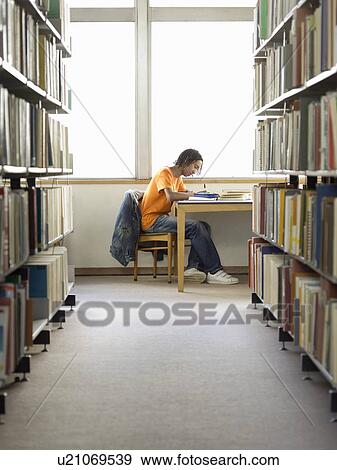 Teenage boy doing homework in library View Large Photo Image Stock Photo - Teenage boy doing homework in library. Fotosearch